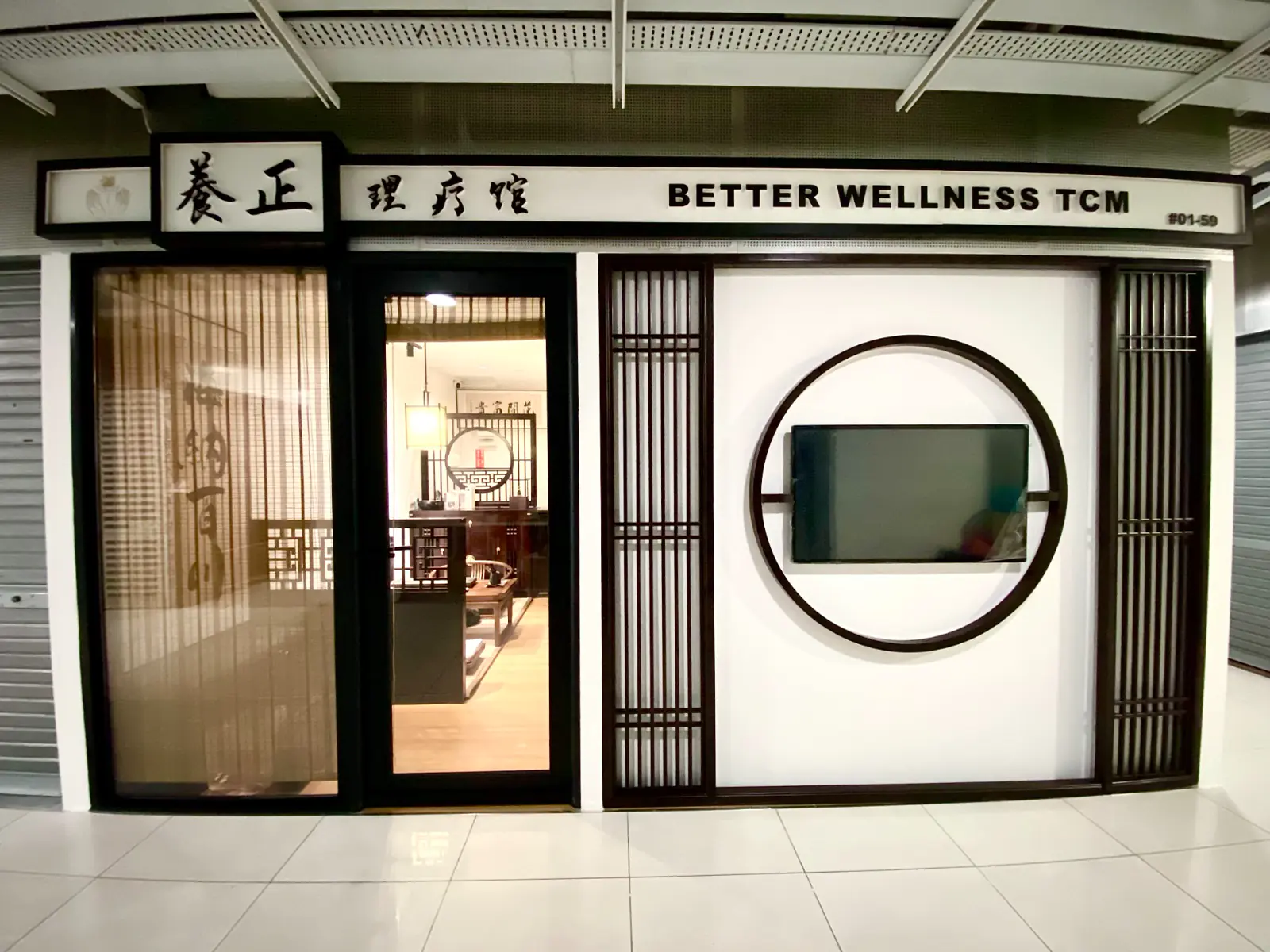 The shopfront — moon-gate frame, rosewood lattice and bilingual signage