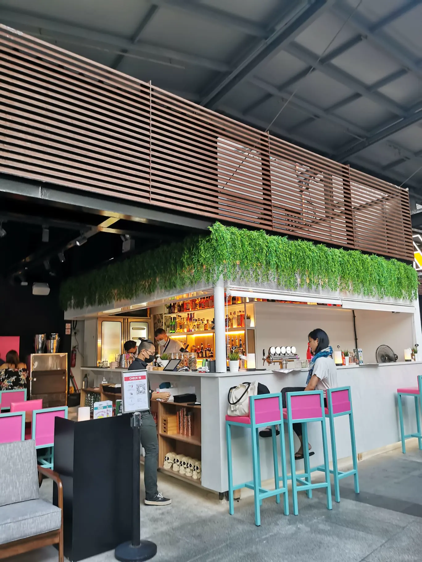 The built counter, hot pink surfaces and turquoise bar stools