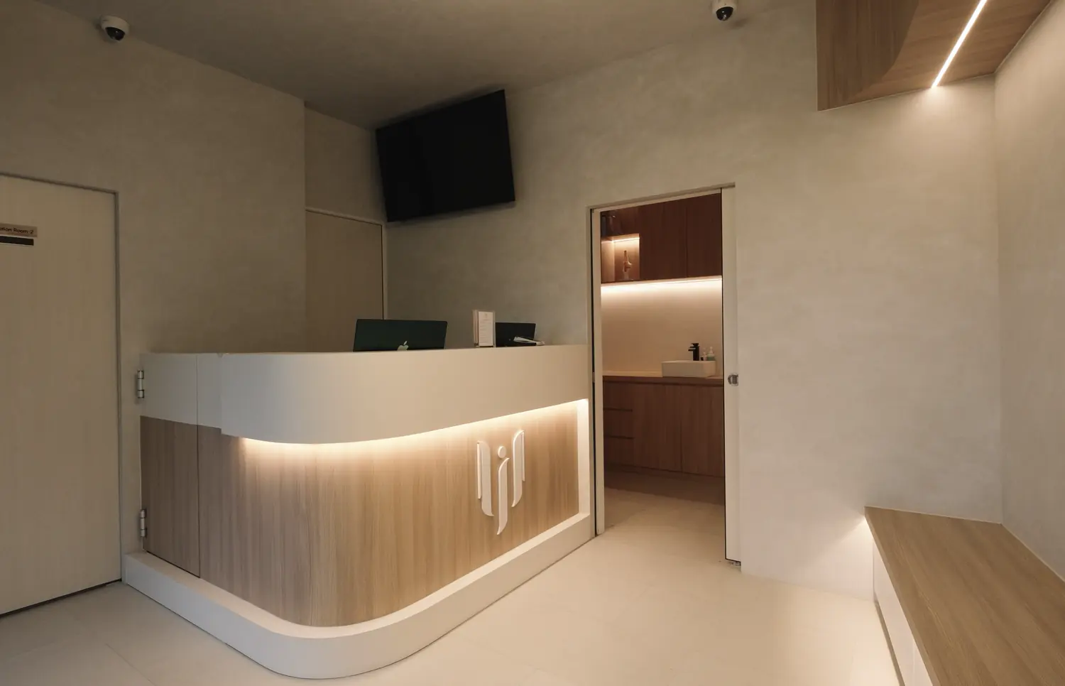 The reception, a curved counter in oak under concealed lighting