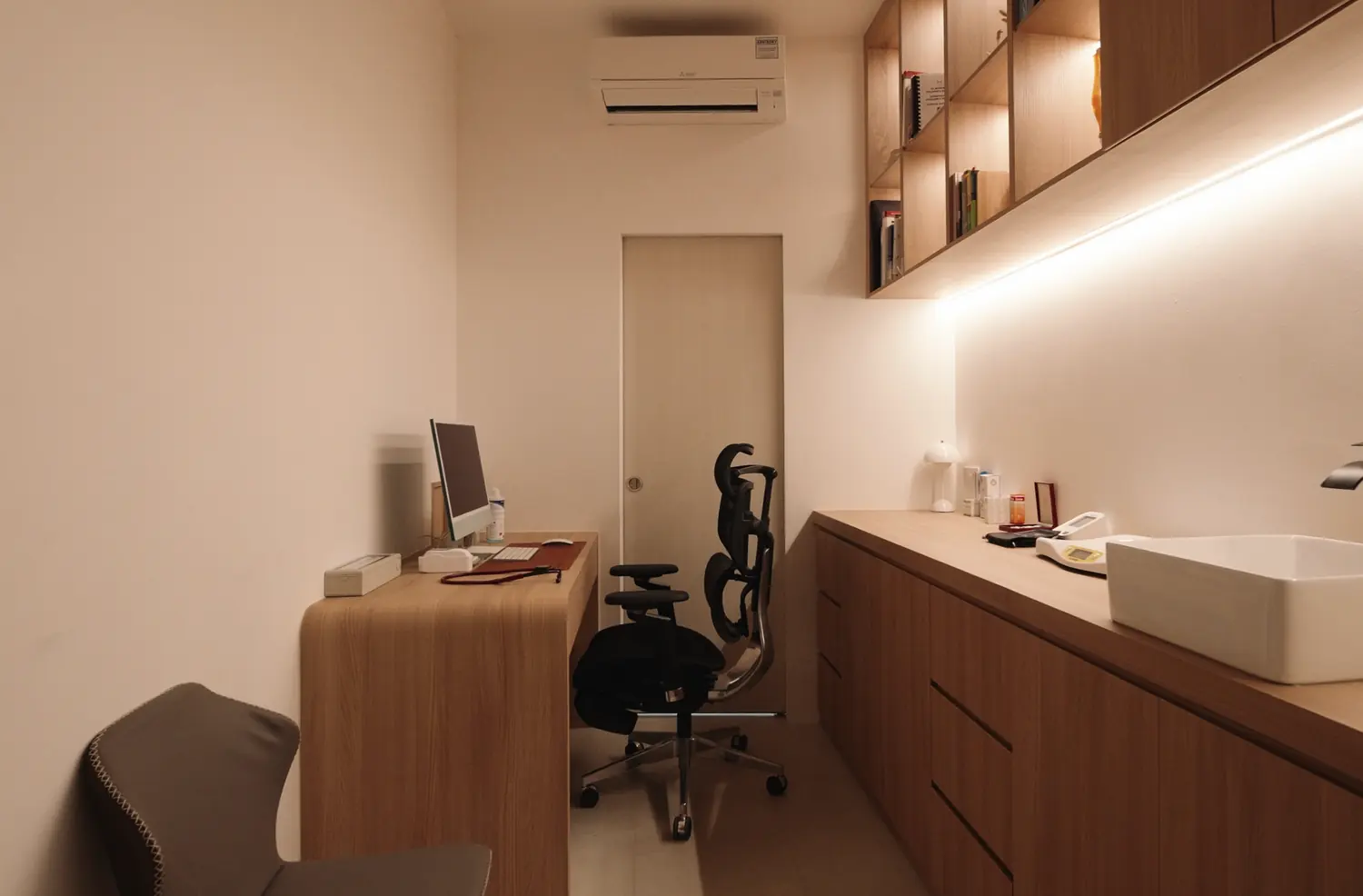 A consultation room, oak joinery running the length of the wall
