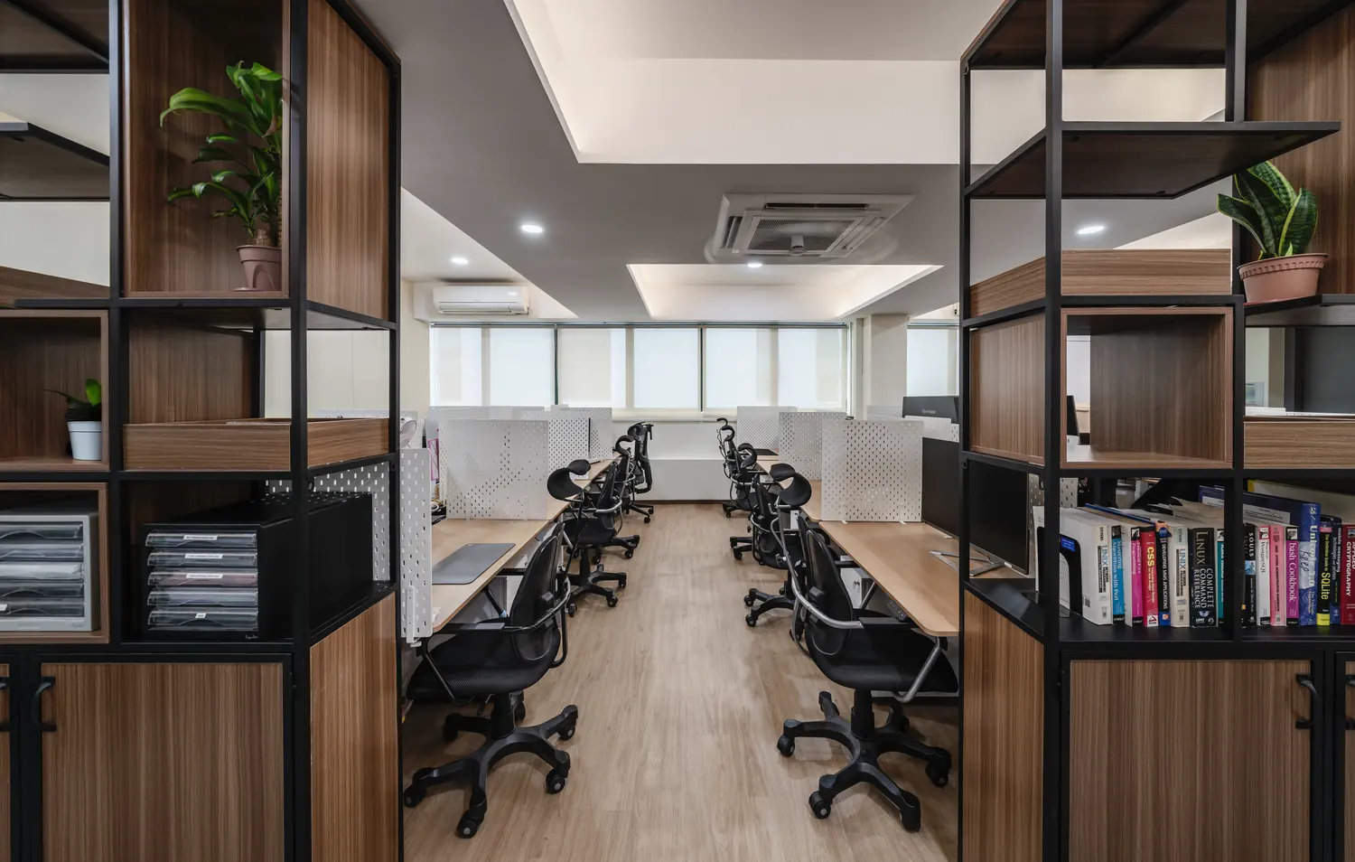 Open workstations divided by black-framed timber shelving