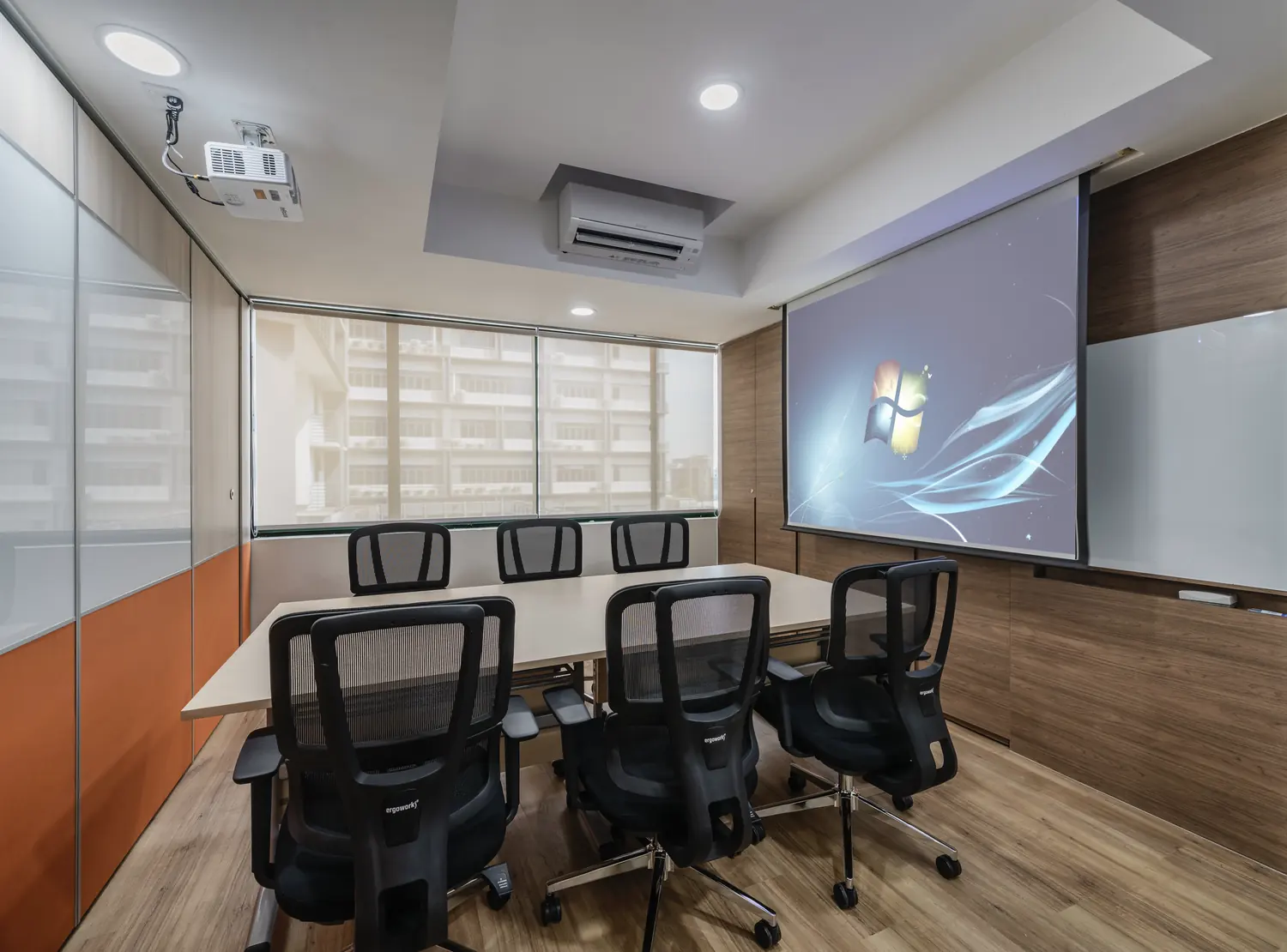 A glass-partitioned meeting room in the company's navy and orange