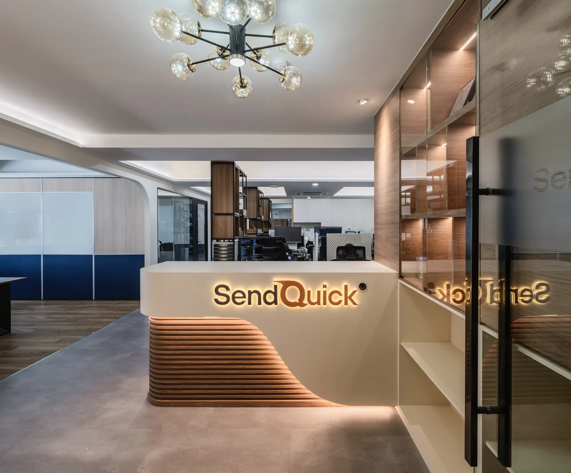 The curved reception counter, its backlit fluted base and illuminated logo