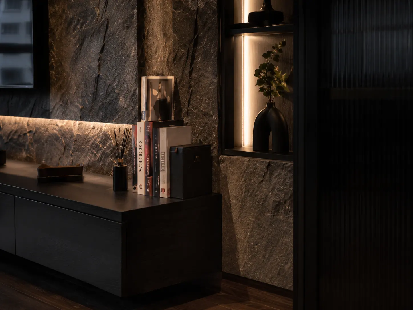 Reeded glass cabinetry and warm cove lighting against textured stone