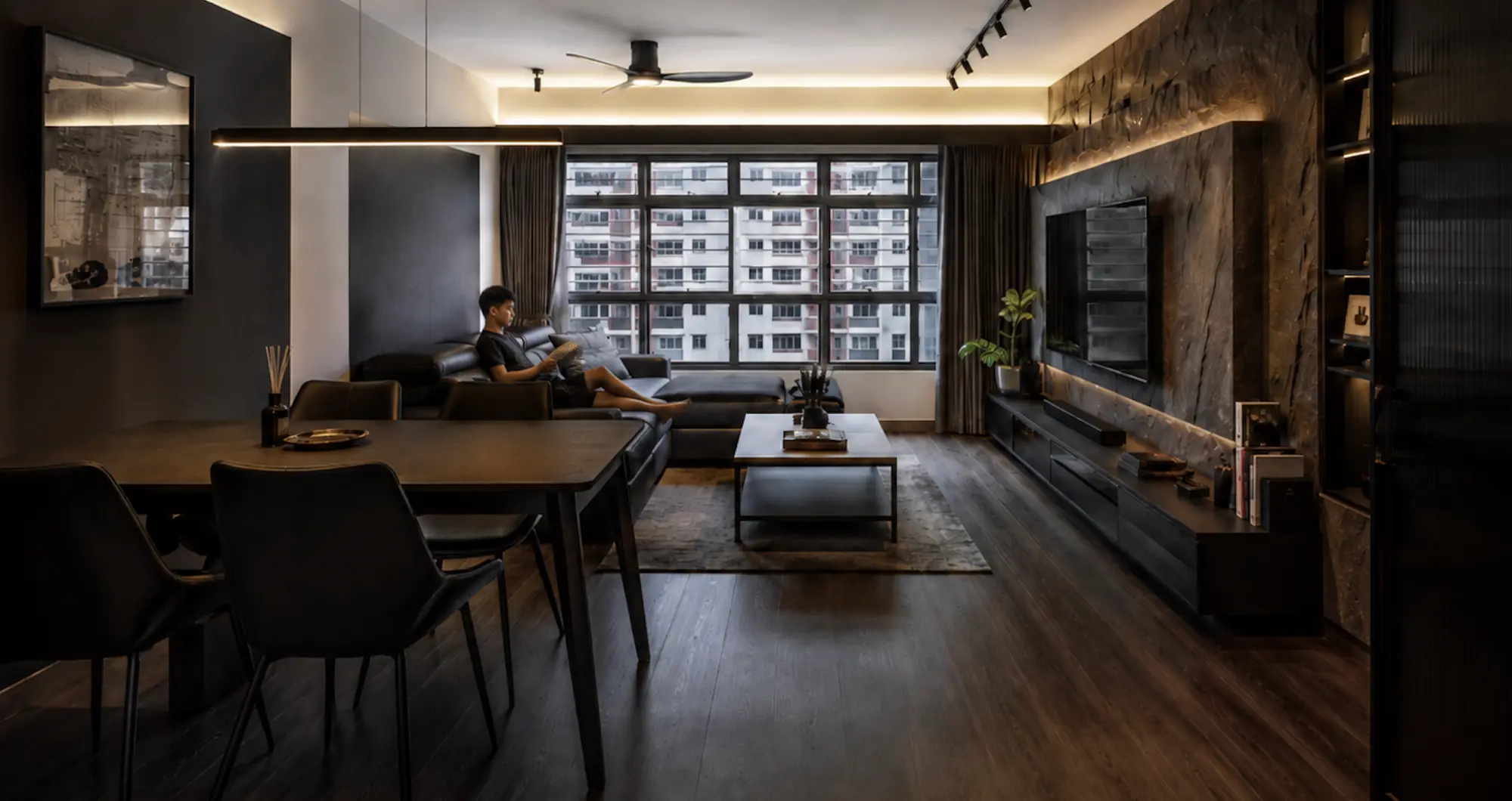 Living and dining seen together, the stone feature wall carrying the length of the plan